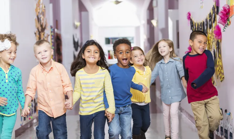 school age children holding hands in hallway